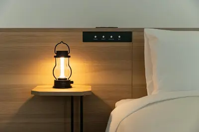 a lamp sitting on a table next to a bed at Tokyu Stay Shibuya Shin-Minamiguchi in Tokyo