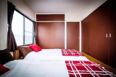 a bedroom with two beds and a window at Murata Corpo 305 in Tokyo