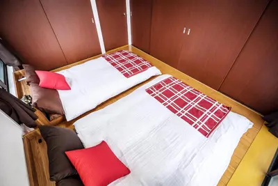 two beds in a small room with red pillows at Murata Corpo 305 in Tokyo