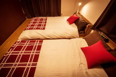a bedroom with two beds with red pillows at Murata Corpo 305 in Tokyo