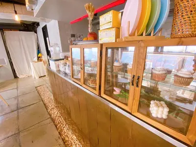 a display case with cupcakes and plates on it at Book Tea Bed SHINJUKU-GYOEN in Tokyo