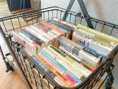 a shopping cart full of books sitting on the floor at Book Tea Bed SHINJUKU-GYOEN in Tokyo