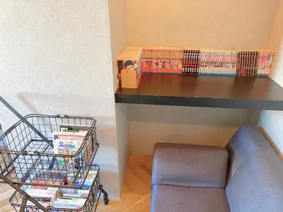 a room with a desk with books and a chair at Book Tea Bed SHINJUKU-GYOEN in Tokyo