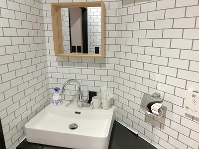 a white bathroom with a sink and a mirror at Book Tea Bed SHINJUKU-GYOEN in Tokyo