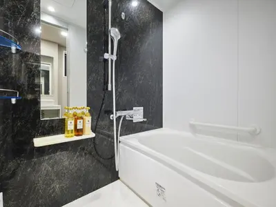 a bathroom with a shower and a tub and a sink at hotel MONday Tokyo Nishikasai in Tokyo
