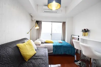 a bedroom with a bed and a couch and a window at Square Shibuya 909 in Tokyo