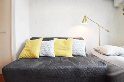 a room with a couch with pillows and a lamp at Square Shibuya 909 in Tokyo