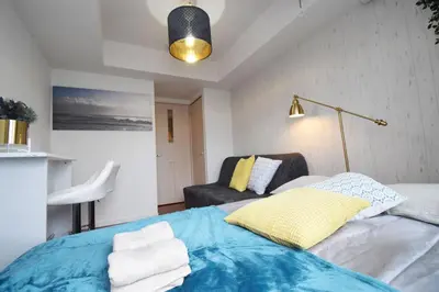 a bedroom with a blue bed and a couch at Square Shibuya 909 in Tokyo