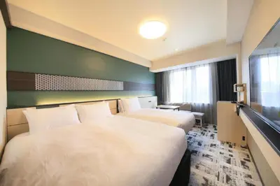 a hotel room with two beds and a flat screen tv at Keisei Richmond Hotel Tokyo Monzennakacho in Tokyo