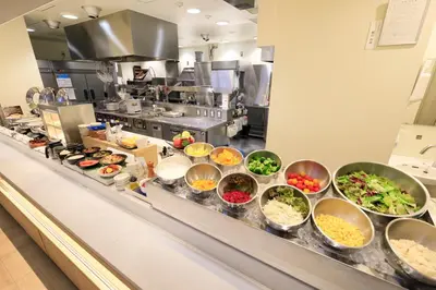 a kitchen with many bowls of food on a counter at Keisei Richmond Hotel Tokyo Monzennakacho in Tokyo