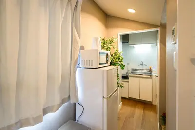 a kitchen with a microwave on top of a refrigerator at Maison Nagasaki 201 in Tokyo