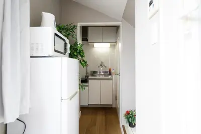 a kitchen with white cabinets and a white refrigerator at Maison Nagasaki 201 in Tokyo