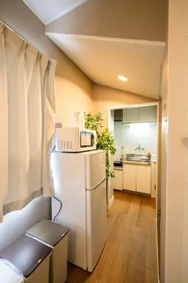 a small kitchen with a refrigerator and a microwave at Maison Nagasaki 201 in Tokyo