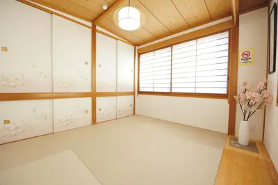 an empty room with windows and a vase of flowers at Asakusa Kei House in Tokyo