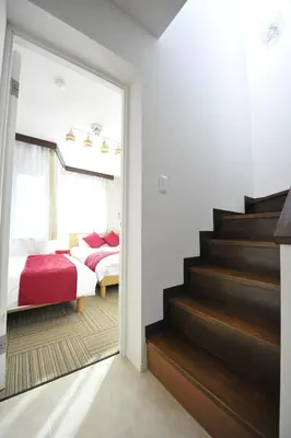 a bedroom with a staircase leading to a bedroom with two beds at Asakusa Kei House in Tokyo