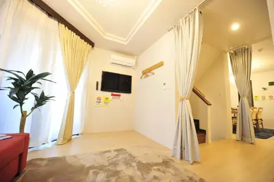 a living room with white walls and curtains at Asakusa Kei House in Tokyo