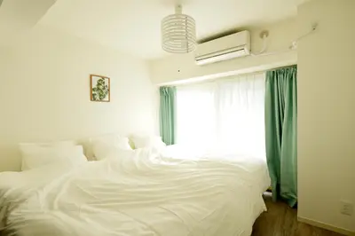 a white bed in a room with a window at Roppongi WoodsHouse501 in Tokyo