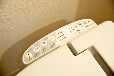 a remote control sitting on the side of a toilet at Roppongi WoodsHouse501 in Tokyo