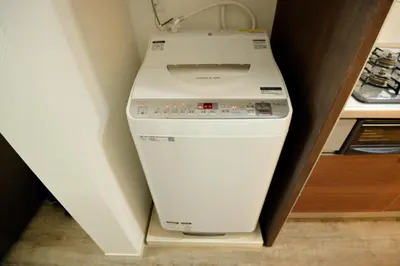 a washer and dryer in a corner of a kitchen at Roppongi WoodsHouse501 in Tokyo