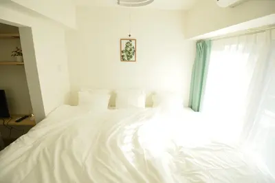 a white bed in a bedroom with a window at Roppongi WoodsHouse501 in Tokyo