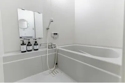 a white bathroom with a tub and a shower at Shimokitazawa Private House in Tokyo
