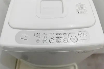a close up of a white washing machine with buttons at Shimokitazawa Private House in Tokyo