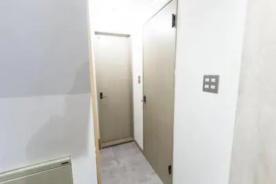 a hallway with two elevators in a white room at Shimokitazawa Private House in Tokyo