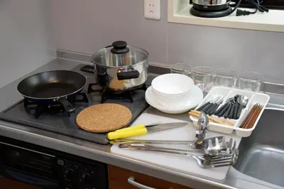a kitchen counter with a stove top with plates and utensils at Roppongi Cat House601 in Tokyo