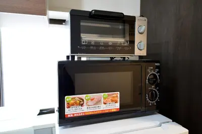 a microwave with a toaster oven on top of it at Roppongi Cat House601 in Tokyo