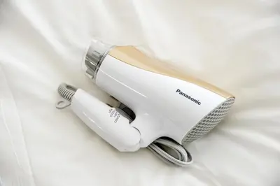 a hair dryer is sitting on a white bed at Roppongi Cat House601 in Tokyo