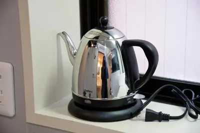 a black and white tea kettle sitting on a counter at Roppongi Cat House601 in Tokyo