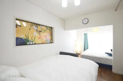 a bedroom with two beds and a painting on the wall at Roppongi Japan House602 in Tokyo