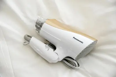 a hair dryer is laying on a white bed at Roppongi Japan House602 in Tokyo