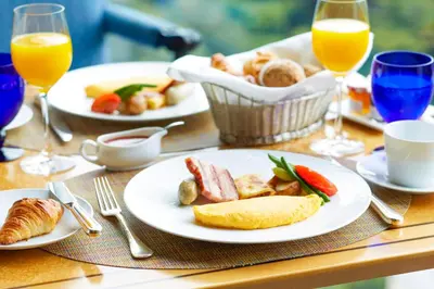a table with plates of food and glasses of orange juice at Hotel Chinzanso Tokyo in Tokyo