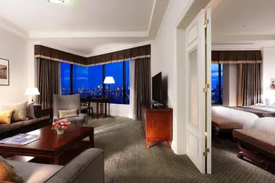 a hotel room with a bed and a living room at Hotel Chinzanso Tokyo in Tokyo