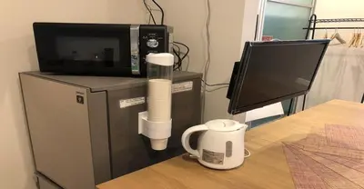 a coffee cup sitting on a table next to a microwave at 3-25-2 Higashiogu - Apartment / Vacation STAY 8342 in Tokyo