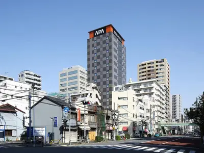 a tall building on a city street with buildings at APA Hotel Ueno Inaricho Ekikita in Tokyo