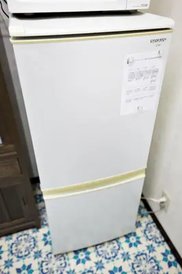 a white refrigerator in a kitchen next to a door at IROHA Residential Suite Asakusa Skytree in Tokyo