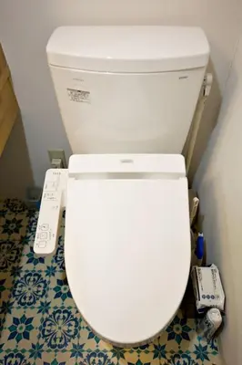 a white toilet with a remote control in a bathroom at IROHA Residential Suite Asakusa Skytree in Tokyo