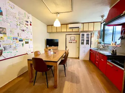a kitchen with a wooden table and red cabinets at Nomad Hostel Classic in Tokyo