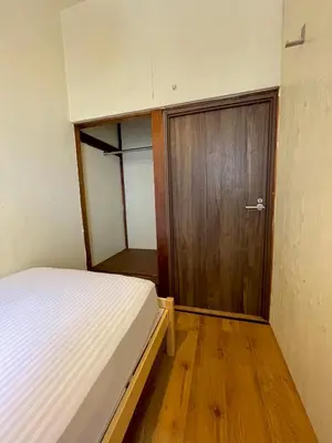 a bedroom with a bed and a wooden door at Nomad Hostel Classic in Tokyo