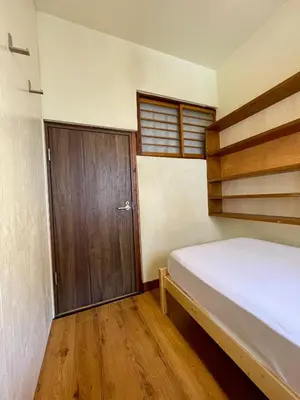 a bedroom with a bed and a wooden door at Nomad Hostel Classic in Tokyo