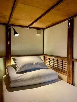 a bed in a room with a wooden ceiling at Nomad Hostel Classic in Tokyo