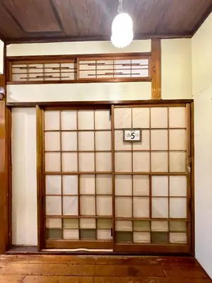 a room with a door with a sign on it at Nomad Hostel Classic in Tokyo