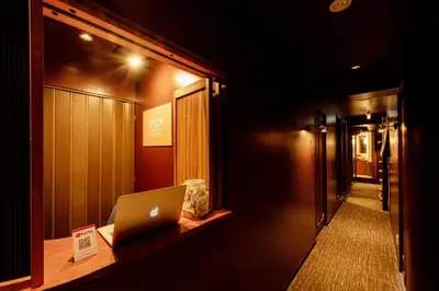 a laptop computer sitting on a desk in a hallway at bnb+ Ueno Okachimachi in Tokyo