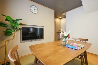 a dining room with a table and a clock on a wall at G48-Superior Room in Shinjuku, Tokyo in Tokyo
