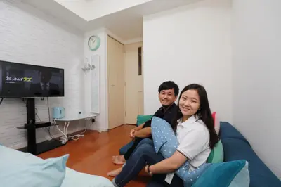 a man and a woman sitting on a couch at IBASHO ShibuyaDogenzaka810 in Tokyo