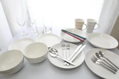 a table with white plates and silverware on it at IBASHO ShibuyaDogenzaka907 in Tokyo