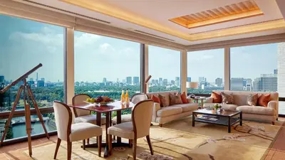 a living room with a table and chairs and windows at The Peninsula Tokyo in Tokyo
