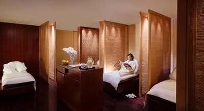 a woman sitting on a bed in a hotel room at The Peninsula Tokyo in Tokyo